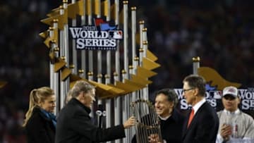 MLB commissioner Bud Selig presents the championship trophy to Boston Red Sox owner John W. Henry (right) and president and ceo Larry Lucchino (center) after game six of the MLB baseball World Series at Fenway Park. Red Sox won 6-1. Mandatory Credit: Greg M. Cooper-USA TODAY Sports
