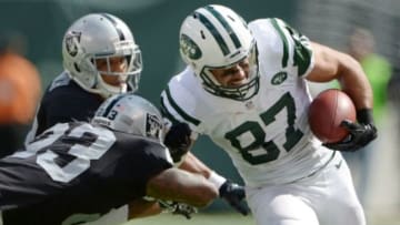 Sep 7, 2014; East Rutherford, NJ, USA; New York Jets receiver Eric Decker (87) is tackled by Oakland Raiders cornerback Tarell Brown (23) and safety Tyvon Branch (33) at MetLife Stadium. The Jets defeated the Raiders 19-14. Mandatory Credit: Kirby Lee-USA TODAY Sports