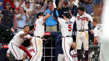 ATLANTA, GEORGIA - OCTOBER 12: Freddie Freeman #5 of the Atlanta Braves high fives Austin Riley #27 and Dansby Swanson #7 after hitting a home run during the eighth inning against the Milwaukee Brewers in game four of the National League Division Series at Truist Park on October 12, 2021 in Atlanta, Georgia. (Photo by Kevin C. Cox/Getty Images)