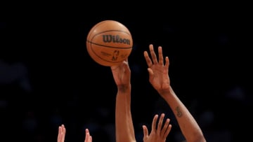 NEW YORK, NEW YORK - NOVEMBER 27: Kevin Durant #7 of the Brooklyn Nets passes the ball under pressure from Cameron Payne #15 and Cameron Johnson #23 of the Phoenix Suns in the first half at Barclays Center on November 27, 2021 in New York City. NOTE TO USER: User expressly acknowledges and agrees that, by downloading and or using this photograph, User is consenting to the terms and conditions of the Getty Images License Agreement. (Photo by Elsa/Getty Images)