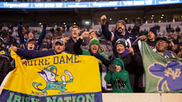 CHARLOTTESVILLE, VA - NOVEMBER 13: Fans of the Notre Dame Fighting Irish cheer in the second half during a game against the Virginia Cavaliers at Scott Stadium on November 13, 2021 in Charlottesville, Virginia. (Photo by Ryan M. Kelly/Getty Images)