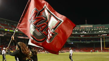 BOSTON, MA - NOVEMBER 11: A Massachusetts Minutemen cheerleader runs with the team flag during the game at Fenway Park on November 11, 2017 in Boston, Massachusetts. (Photo by Omar Rawlings/Getty Images)