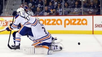 Dec 3, 2014; Winnipeg, Manitoba, CAN; Winnipeg Jets forward Mathieu Perreault (85) tips a Winnipeg Jets defenceman Jacob Trouba (8) (not shown) shot past Edmonton Oilers goalie Ben Scrivens (30) during the overtime period at MTS Centre. Winnipeg wins in overtime 3-2. Mandatory Credit: Bruce Fedyck-USA TODAY Sports