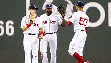 BOSTON, MA - AUGUST 22: Andrew Benintendi #16, Jackie Bradley Jr. #19 and Mookie Betts #50 of the Boston Red Sox embrace after a victory over the Cleveland Indians at Fenway Park on August 22, 2018 in Boston, Massachusetts. (Photo by Adam Glanzman/Getty Images)