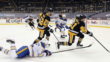May 6, 2021; Pittsburgh, Pennsylvania, USA; Pittsburgh Penguins center Frederick Gaudreau (11) clears the puck against Buffalo Sabres center Arttu Ruotsalainen (25) during the second period at PPG Paints Arena. Mandatory Credit: Charles LeClaire-USA TODAY Sports
