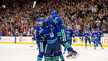 VANCOUVER, BC - NOVEMBER 02: Vancouver Canucks defenseman Derrick Pouliot (5) celebrates with right wing Brock Boeser (6) center Bo Horvat (53) and center Elias Pettersson (40) after scoring a goal in overtime during their NHL game against the Colorado Avalanche at Rogers Arena on November 2, 2018 in Vancouver, British Columbia, Canada. Vancouver won 7-6. (Photo by Derek Cain/Icon Sportswire via Getty Images)
