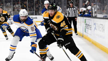 Jan 1, 2022; Boston, Massachusetts, USA; Boston Bruins defenseman Matt Grzelcyk (48) controls the puck in front of Buffalo Sabres right wing Alex Tuch (89) during the first period at TD Garden. Mandatory Credit: Brian Fluharty-USA TODAY Sports