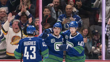 VANCOUVER, BC - FEBRUARY 22: Bo Horvat #53 of the Vancouver Canucks celebrates with Quinn Hughes #43 and Elias Pettersson #40 after scoring a goal against the Boston Bruins during NHL action at Rogers Arena on February 22, 2020 in Vancouver, Canada. (Photo by Rich Lam/Getty Images)