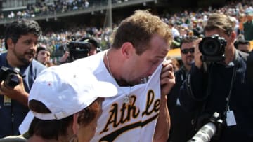 OAKLAND, CA - MAY 09: Dallas Braden #51 of the Oakland Athletics celebrates after pitching a perfect game against the Tampa Bay Rays with his grandmother Peggy Lindsey during an MLB game at the Oakland-Alameda County Coliseum on May 9, 2010 in Oakland, California. Braden is seen kissing his mother's wedding ring who passed away. (Photo by Jed Jacobsohn/Getty Images)