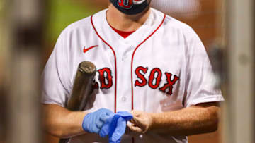 BOSTON, MA - JULY 28: The ball boy wears a protective face mask as he puts on medical latex gloves during the sixth inning of a game between the Boston Red Sox and the New York Mets at Fenway Park on July 28, 2020 in Boston, Massachusetts. (Photo by Adam Glanzman/Getty Images)