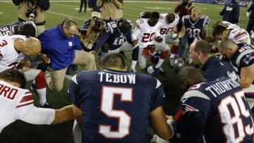 Aug 29, 2013; Foxborough, MA, USA; New England Patriots quarterback Tim Tebow (5) joins other players from his team and the New York Giants for a prayer on the field after the game Gillette Stadium. The Patriots defeated the Giants 28-20. Mandatory Credit: David Butler II-USA TODAY Sports
