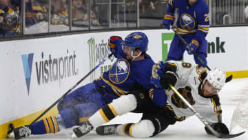 Dec 31, 2022; Boston, Massachusetts, USA; Buffalo Sabres defenseman Mattias Samuelsson (23) and Boston Bruins center Pavel Zacha (18) go down battling for the puck during the first period at TD Garden. Mandatory Credit: Winslow Townson-USA TODAY Sports