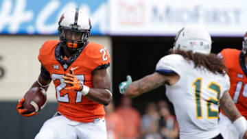 STILLWATER, OK - SEPTEMBER 3 : Running back Justice Hill #27 of the Oklahoma State Cowboys evades defensive back Max Lyons #12 of the Southeastern Louisiana Lions September 3, 2016 at Boone Pickens Stadium in Stillwater, Oklahoma. The Cowboys defeated the Lions 61-7. (Photo by Brett Deering/Getty Images)