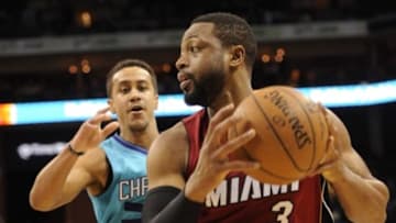 Jan 21, 2015; Charlotte, NC, USA; Miami Heat guard Dwyane Wade (3) looks to pass as he is defended by Charlotte Hornets guard Brian Roberts (22) during the first half of the game at Time Warner Cable Arena. Mandatory Credit: Sam Sharpe-USA TODAY Sports