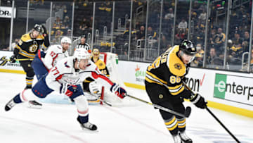 May 21, 2021; Boston, Massachusetts, USA; Boston Bruins defenseman Kevan Miller (86) controls the puck away from Washington Capitals right wing T.J. Oshie (77) during the first period in game four of the first round of the 2021 Stanley Cup Playoffs at TD Garden. Mandatory Credit: Bob DeChiara-USA TODAY Sports