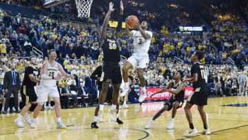 ANN ARBOR, MICHIGAN - JANUARY 09: Zavier Simpson #3 of the Michigan Wolverines shoots over Trevion Williams #50 of the Purdue Boilermakers during the overtime period of a college basketball game at Crisler Center on January 9, 2020 in Ann Arbor, MI. The Michigan Wolverines won the game 84-78 in double overtime over the Purdue Boilermakers. (Photo by Aaron J. Thornton/Getty Images)
