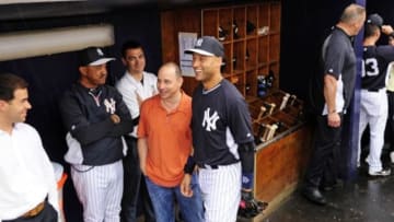 Mar 29, 2014; Tampa, FL, USA; New York Yankees shortstop Derek Jeter (2) talks with general manager Brian Cashman as a scheduled spring training exhibition game against the Miami Marlins at George M. Steinbrenner Field was rained out. Mandatory Credit: David Manning-USA TODAY Sports