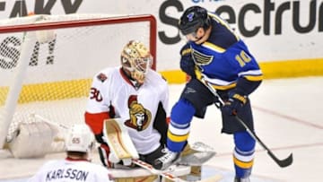 Jan 4, 2016; St. Louis, MO, USA; St. Louis Blues right wing Scottie Upshall (10) attempts to deflect the puck against Ottawa Senators goalie Andrew Hammond (30) during the third period at Scottrade Center. The Ottawa Senators defeat the St. Louis Blues 3-2 in overtime. Mandatory Credit: Jasen Vinlove-USA TODAY Sports