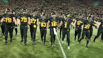 IOWA CITY, IA - NOVEMBER 14: Members of the Iowa Hawkeyes swarm the field to collect The Floyd of Rosedale trophy after defeating the Minnesota Gophers on November 14, 2015 at Kinnick Stadium, in Iowa City, Iowa. (Photo by Matthew Holst/Getty Images)