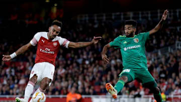 LONDON, ENGLAND - SEPTEMBER 20: Pierre-Emerick Aubameyang of Arsenal scores his team's third goal as Artur Sergio Batista de Souza of Vorskla Poltava attempts to block during the UEFA Europa League Group E match between Arsenal and Vorskla Poltava at Emirates Stadium on September 20, 2018 in London, United Kingdom. (Photo by Henry Browne/Getty Images)