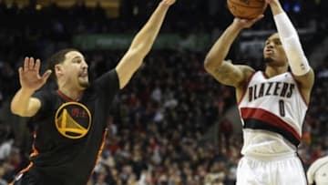 Feb 19, 2016; Portland, OR, USA; Portland Trail Blazers guard Damian Lillard (0) hits a three point shot over Golden State Warriors guard Klay Thompson (11) during the third quarter of the game at the Moda Center at the Rose Quarter. Lillard scored 51 points as the Blazers won 137-105. Mandatory Credit: Steve Dykes-USA TODAY Sports