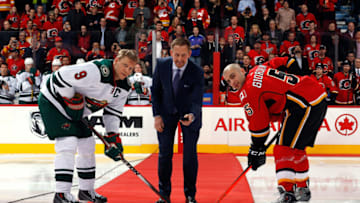 CALGARY, AB - JANUARY 29: Gary Roberts participates in a ceremonial puck drop before the game with Mark Giordano #5 of the Calgary Flames and Mikko Koivu #9 of the Minnesota Wild at Scotiabank Saddledome on January 29, 2015 in Calgary, Alberta, Canada. (Photo by Gerry Thomas/NHLI via Getty Images)