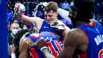 Luka Garza #55 and Hamidou Diallo #6 of the Detroit Pistons pour water on Saddiq Bey (Photo by Nic Antaya/Getty Images)