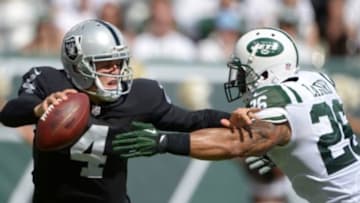 Sep 7, 2014; East Rutherford, NJ, USA; Oakland Raiders quarterback Derek Carr (4) is sacked by New York Jets safety Dawan Landry (26) at MetLife Stadium. The Jets defeated the Raiders 19-14. Mandatory Credit: Kirby Lee-USA TODAY Sports