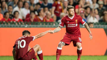 HONG KONG, HONG KONG - JULY 22: Liverpool FC midfielder Philippe Coutinho (L) is helped up by teammate Alberto Moreno during the Premier League Asia Trophy match between Liverpool FC and Leicester City FC at Hong Kong Stadium on July 22, 2017 in Hong Kong, Hong Kong. (Photo by Victor Fraile/Getty Images )