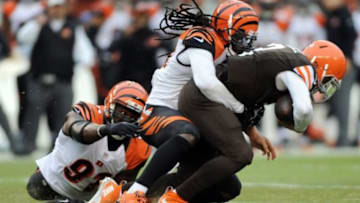 Dec 14, 2014; Cleveland, OH, USA; Cleveland Browns quarterback Johnny Manziel (2) is tackled by Cincinnati Bengals defensive end Robert Geathers (91) and free safety Reggie Nelson (20) during the first quarter at FirstEnergy Stadium. Mandatory Credit: Ken Blaze-USA TODAY Sports