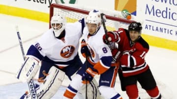 Sep 19, 2013; Newark, NJ, USA; New York Islanders goalie Kevin Poulin (60) and defenseman Griffin Reinhart (8) defend the goal against New Jersey Devils right wing Stephen Gionta (11) during the first period at Prudential Center. Mandatory Credit: Noah K. Murray-USA TODAY Sports