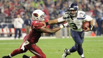 Dec 21, 2014; Glendale, AZ, USA; Seattle Seahawks quarterback Russell Wilson (3) sheds the tackle of Arizona Cardinals outside linebacker Alex Okafor (57) en route to a touchdown during the second half at University of Phoenix Stadium. The Seahawks won 35-6. Mandatory Credit: Joe Camporeale-USA TODAY Sports