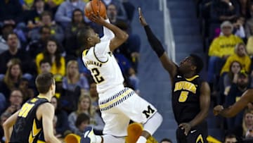 Mar 5, 2016; Ann Arbor, MI, USA; Michigan Wolverines guard Muhammad-Ali Abdur-Rahkman (12) shoots over Iowa Hawkeyes guard Anthony Clemmons (5) in the second half at Crisler Center. Iowa won 71-61. Mandatory Credit: Rick Osentoski-USA TODAY Sports