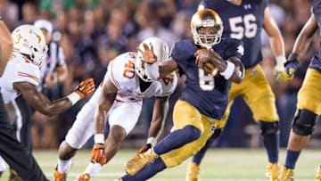 Sep 5, 2015; South Bend, IN, USA; Notre Dame Fighting Irish quarterback Malik Zaire (8) runs the ball as Texas Longhorns defensive end Naashon Hughes (40) pursues in the second quarter at Notre Dame Stadium. Mandatory Credit: Matt Cashore-USA TODAY Sports