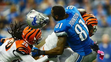 Oct 20, 2013; Detroit, MI, USA; Detroit Lions wide receiver Calvin Johnson (81) loses his helmet while being hit by Cincinnati Bengals free safety Reggie Nelson (20) and strong safety George Iloka (43) during the second quarter at Ford Field. Mandatory Credit: Andrew Weber-USA TODAY Sports