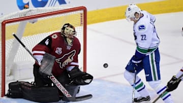 Nov 23, 2016; Glendale, AZ, USA; Vancouver Canucks left wing Daniel Sedin (22) tries to recover a rebound as Arizona Coyotes goalie Mike Smith (41) defends during the first period at Gila River Arena. Mandatory Credit: Matt Kartozian-USA TODAY Sports