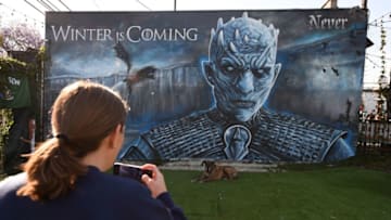 A woman takes a photo of her dog in front of a "Game of Thrones" mural outside Brennan's bar before a viewing party for HBO's "Game of Thrones" series finale in Marina del Rey, California, May 19, 2019. (Photo by Robyn Beck / Robyn Beck / AFP) (Photo credit should read ROBYN BECK/AFP/Getty Images)