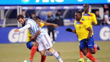 Nov 15, 2013; East Rutherford, NJ, USA; Ecuador midfielder Jorge Guagua (2) tackles Argentina forward Gonzalo Higuain (9) during the second half at MetLife Stadium. The match ended in a 0-0 draw. Mandatory Credit: Joe Camporeale-USA TODAY Sports