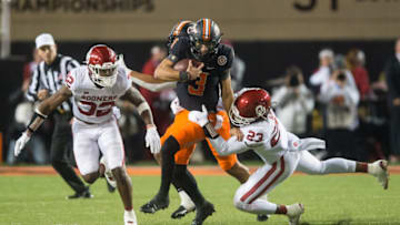 Nov 27, 2021; Stillwater, Oklahoma, USA; Oklahoma Sooners linebacker DaShaun White (23) tackles Oklahoma State Cowboys quarterback Spencer Sanders (3) as Oklahoma safety Delarrin Turner-Yell (32) closes in during the second quarter at Boone Pickens Stadium. Mandatory Credit: Brett Rojo-USA TODAY Sports