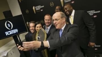 Jul 14, 2014; Irving, TX, USA; College football playoff executive director Bill Hancock takes a selfie with the new championship trophy during a press conference at the college football playoff headquarters. Mandatory Credit: Kevin Jairaj-USA TODAY Sports