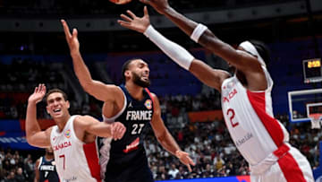 Canada's Shai Gilgeous-Alexander shoots as France's Rudy Gobert (C) tries to block during the FIBA Basketball World Cup group H match between Canada and France at Indonesia Arena in Jakarta on August 25, 2023. (Photo by ADEK BERRY / AFP) (Photo by ADEK BERRY/AFP via Getty Images)