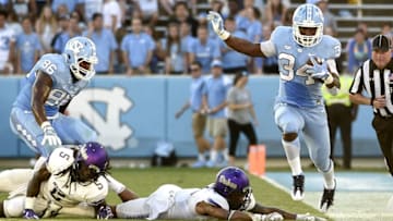 Sep 17, 2016; Chapel Hill, NC, USA; North Carolina Tar Heels running back Elijah Hood (34) with the ball as James Madison Dukes safety Raven Greene (5) and linebacker Brandon Hereford (49) defend in the fourth quarter at Kenan Memorial Stadium. The Tar Heels defeated the James Madison Dukes 56-28. Mandatory Credit: Bob Donnan-USA TODAY Sports