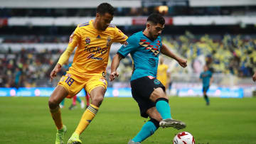 Diego Reyes y Henry Martin pelean un balón.