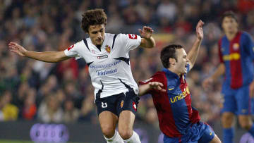 Barcelona's Andres Iniesta (R) vies with