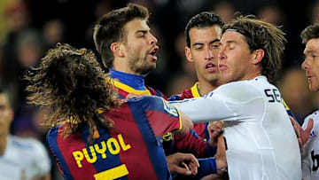 Barcelona's captain Carles Puyol (L) rea