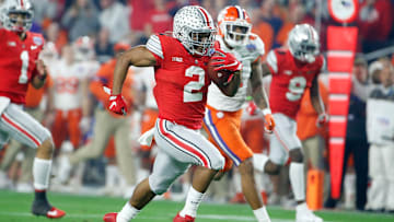 JK Dobbins running away from defenders in the Fiesta Bowls vs. Clemson