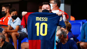 Un señor mostrando una camiseta de Messi