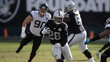 Oakland Raiders running back Josh Jacobs bursting through the hole vs. the Jacksonville Jaguars