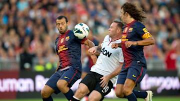 Mascherano y Puyol marcando a Rooney