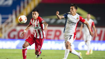 Jugadores de Chivas y Necaxa pelean un balón.